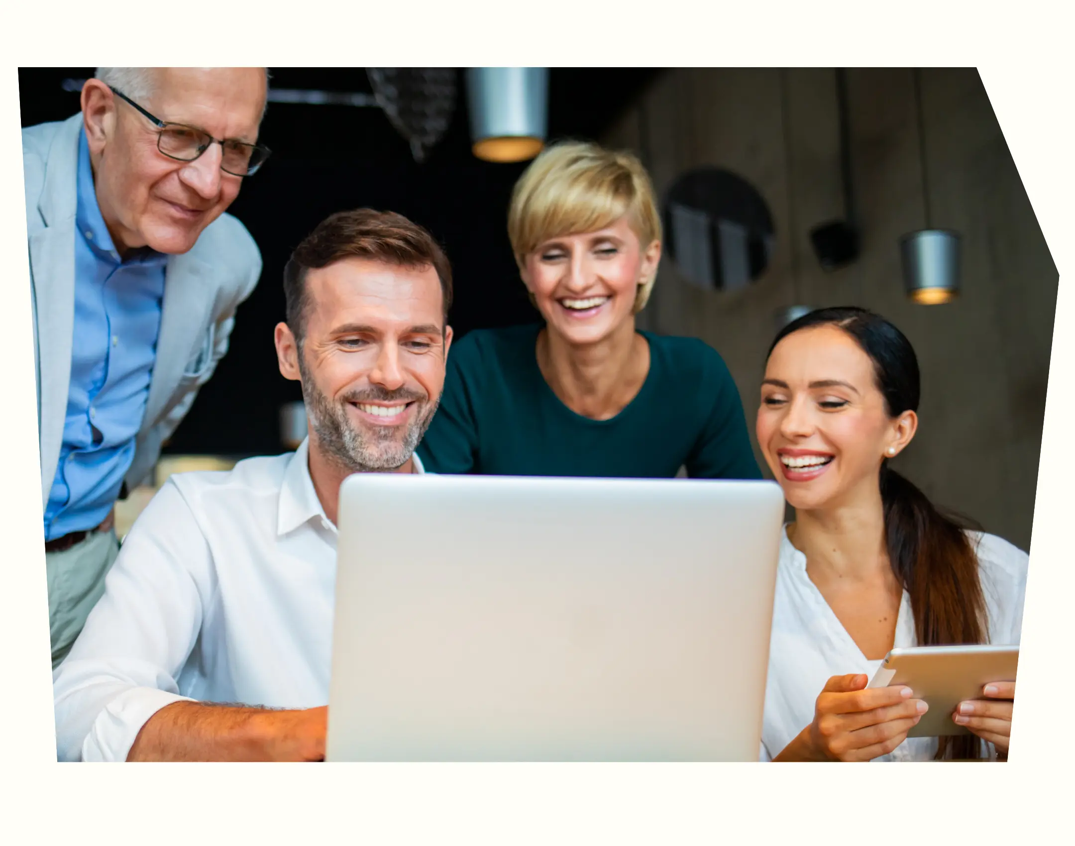 four HR leaders looking at a laptop screen smiling